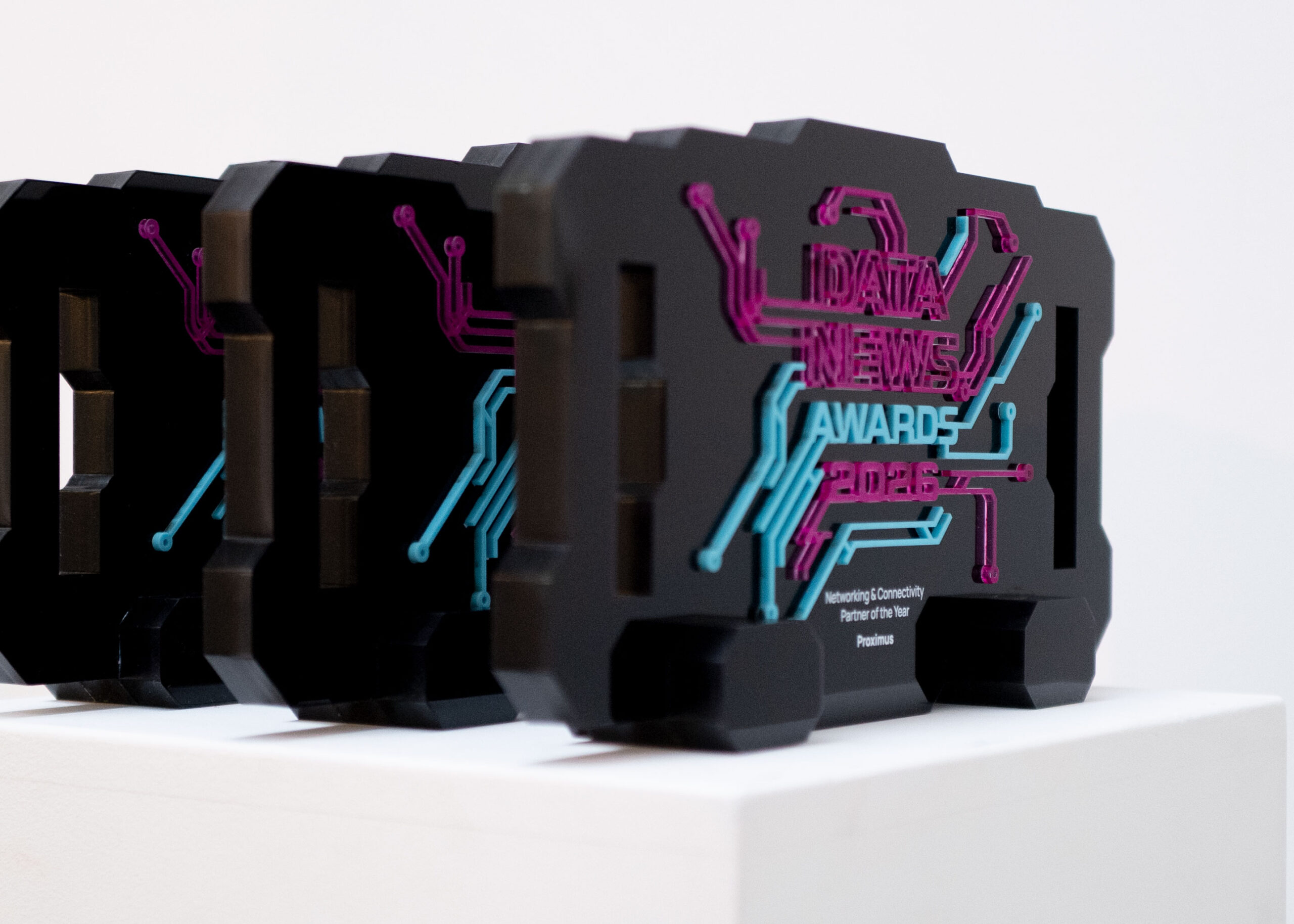 DATANEWS_2 Reeks Datanews Awards 2026 naast elkaar op een witte sokkel