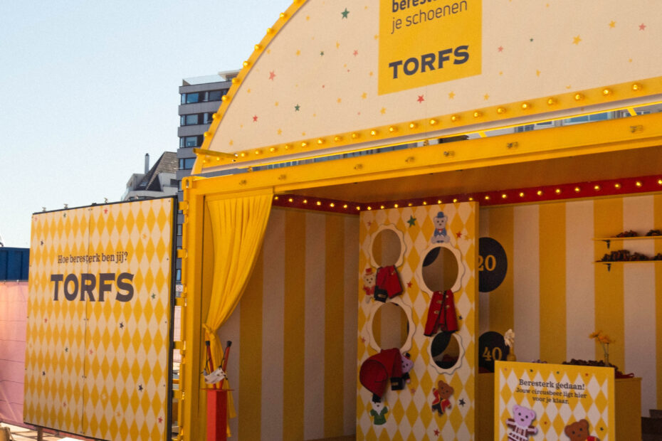 Zijaanzicht van de omgebouwde Torfs-container met krachtmeter op Circus Camille
