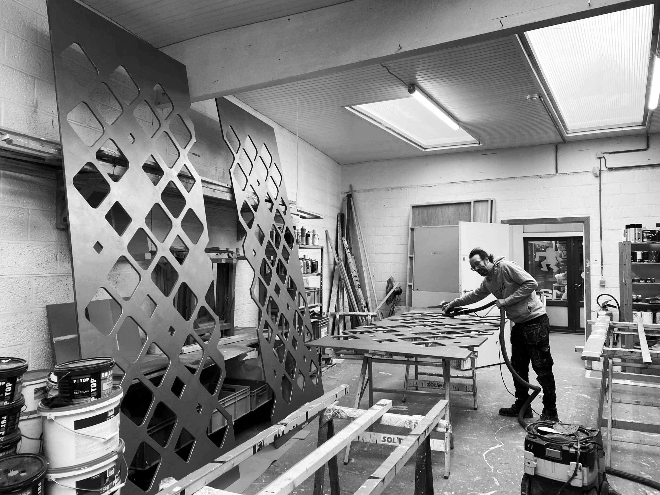 IMG_2306-ZW Afwerking van de panelen met uitgesneden ruiten in het atelier van Vrijeruimte